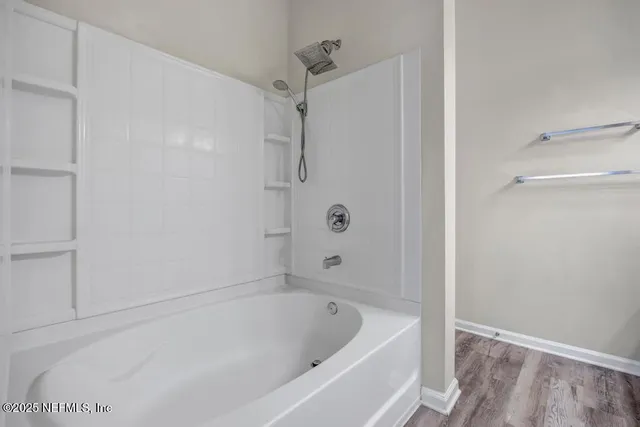 a white bath tub sitting next to a shower
