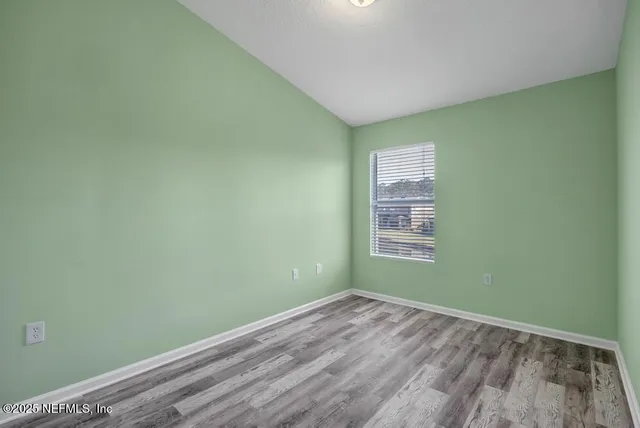 a view of a room with wooden floor and windows