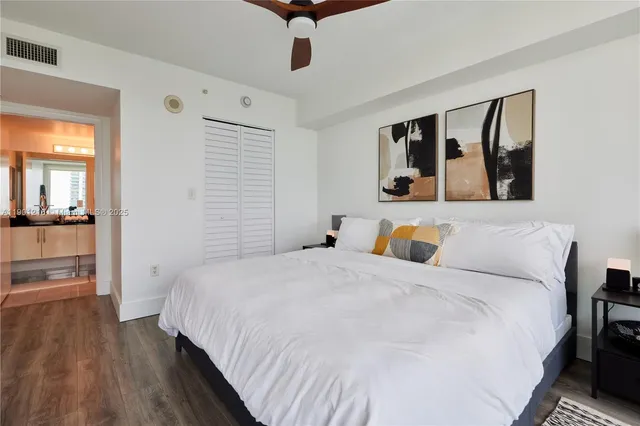 a bedroom with a large bed and a view of kitchen
