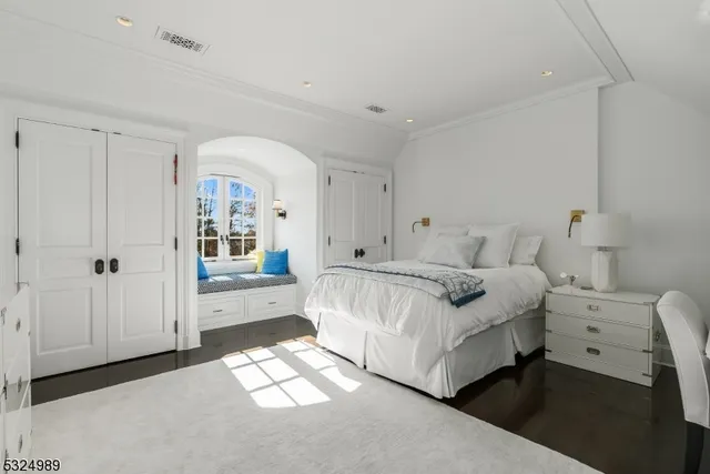 a spacious bedroom with a bed and a dresser