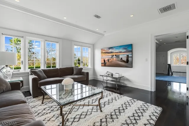 a living room with furniture wooden floor and a large window