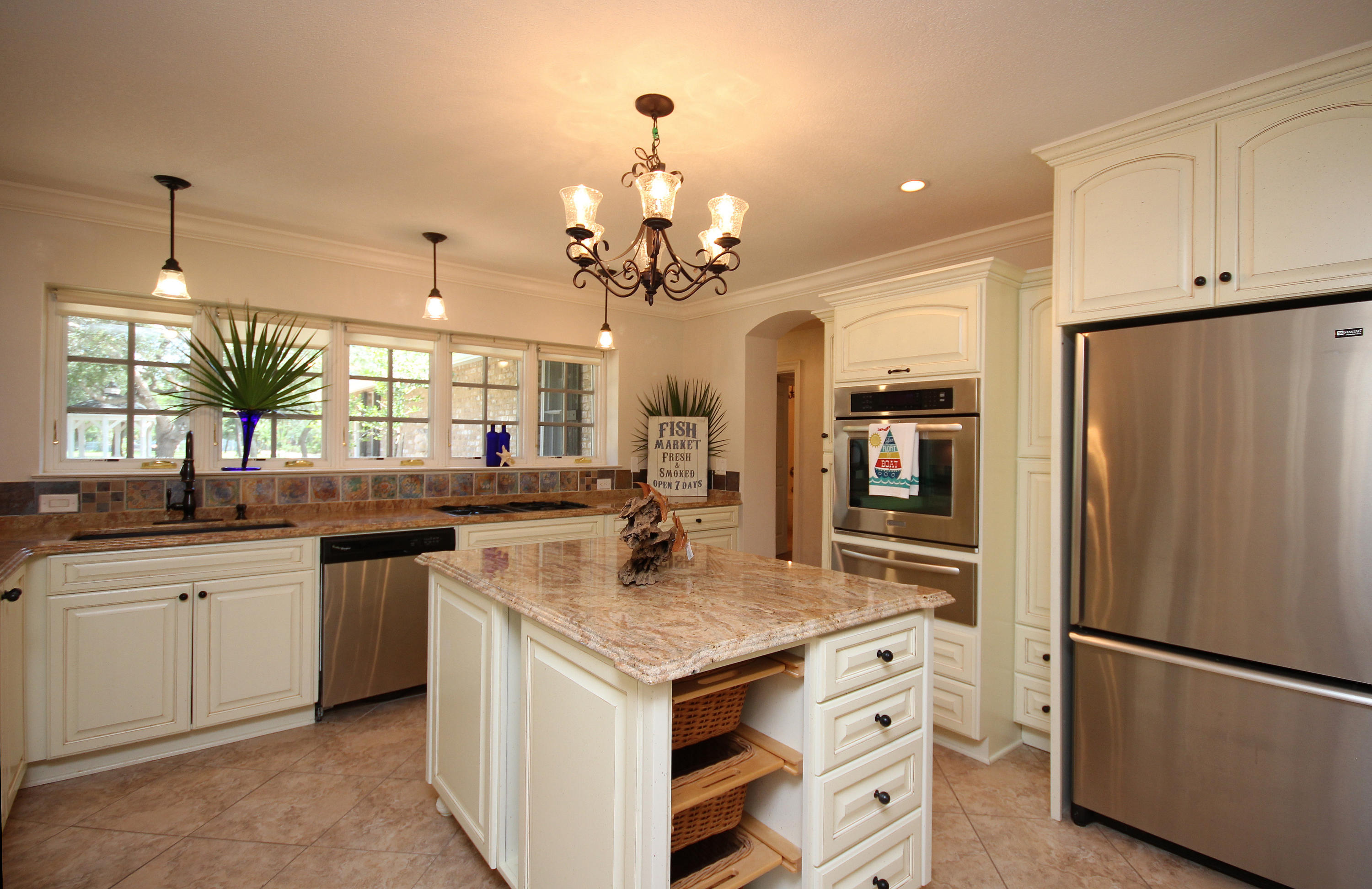 497 Walton Way Miramar Beach, FL 32550 - Photo 19 of 47 a kitchen with center island cabinets and refrigerator