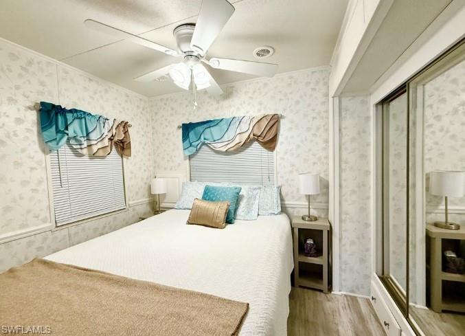 458 Vanda Sanctuary Naples, FL 34114 - Photo 23 of 50 a bedroom with a bed and a chandelier