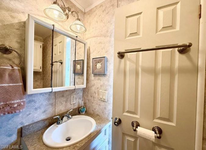 458 Vanda Sanctuary Naples, FL 34114 - Photo 27 of 50 a bathroom with a sink and a mirror