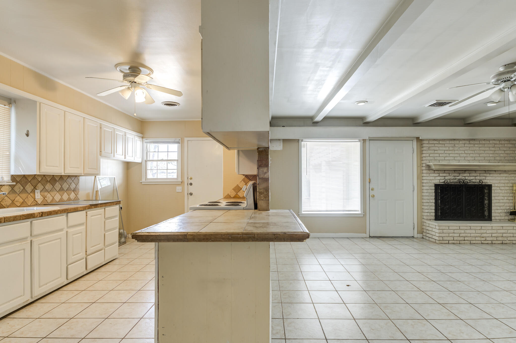 2420 39th Street Lubbock, TX 79412 - Photo 14 of 39 a kitchen with kitchen island granite countertop a stove a sink and a refrigerator