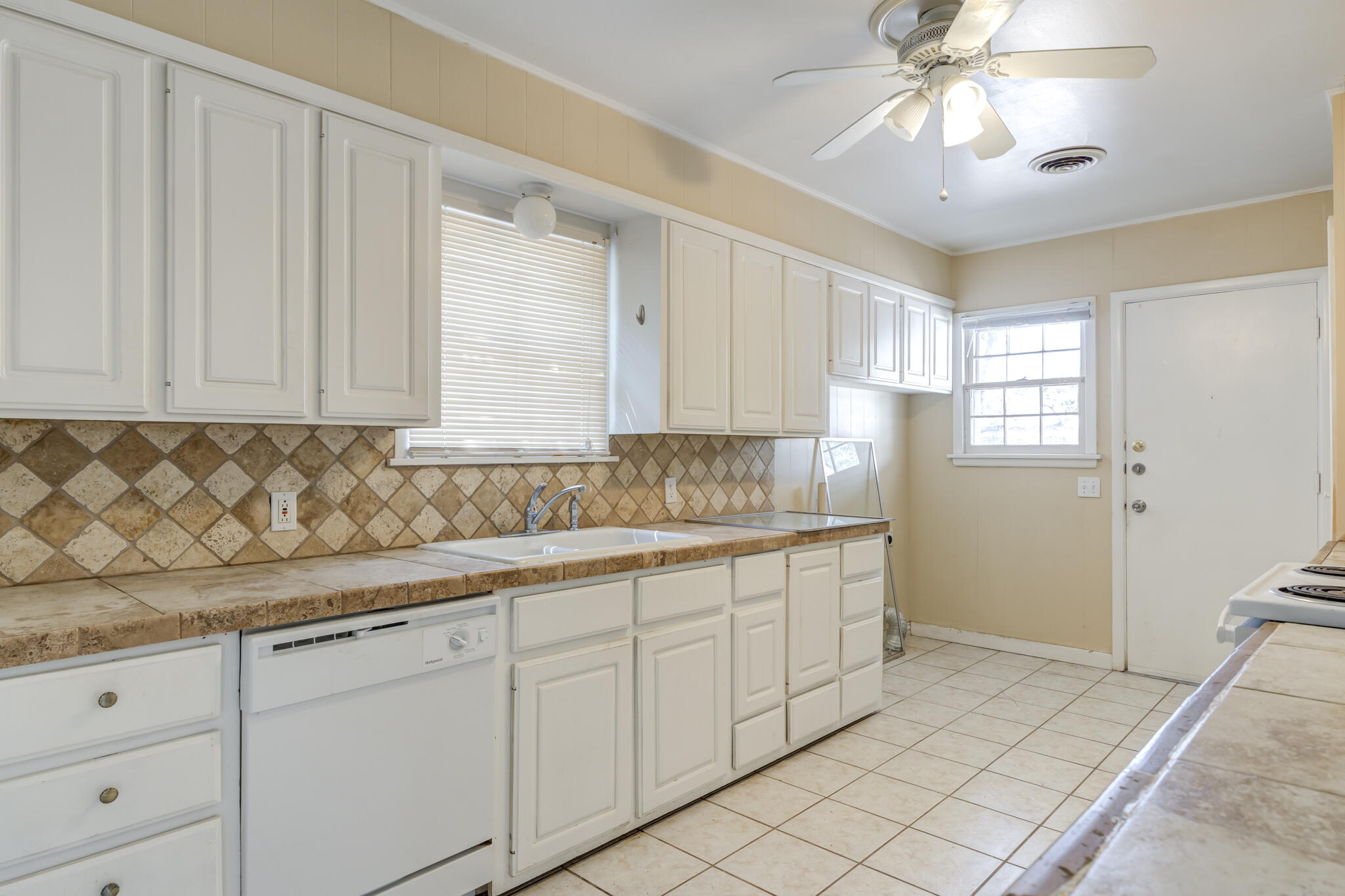 2420 39th Street Lubbock, TX 79412 - Photo 15 of 39 a kitchen with granite countertop white cabinets and stainless steel appliances
