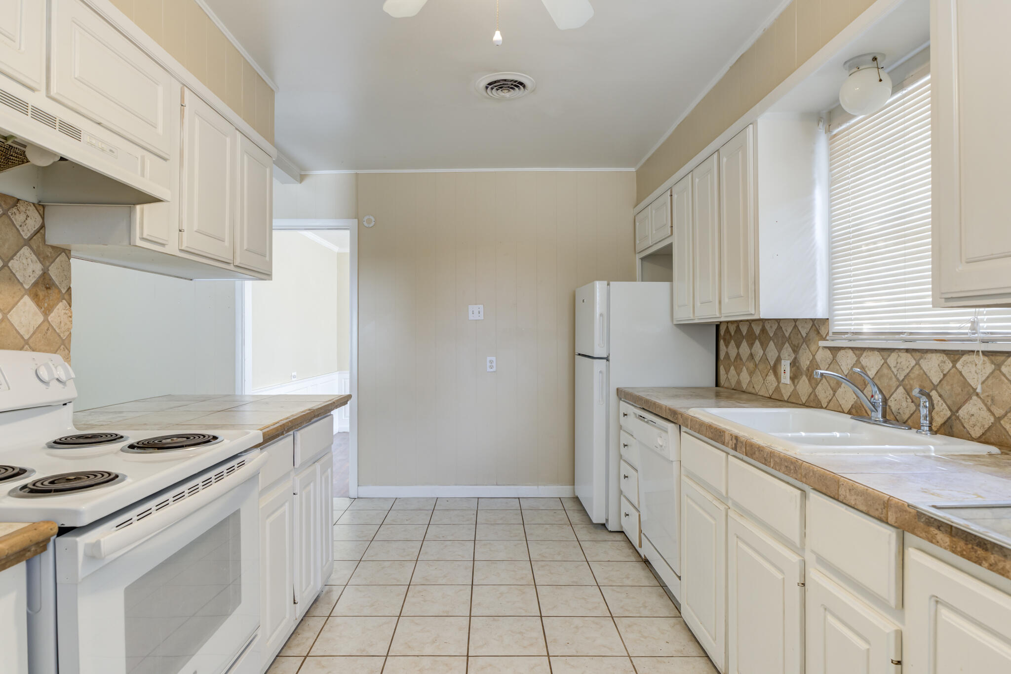2420 39th Street Lubbock, TX 79412 - Photo 19 of 39 a kitchen with a sink stove and cabinets