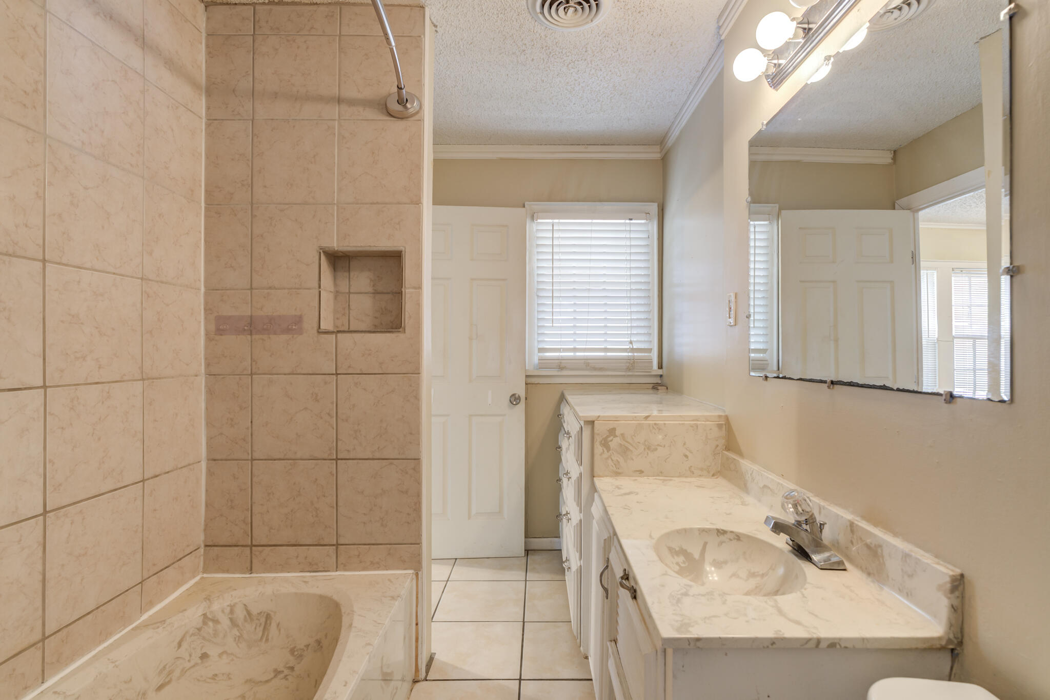 2420 39th Street Lubbock, TX 79412 - Photo 33 of 39 a bathroom with a tub a sink and a shower