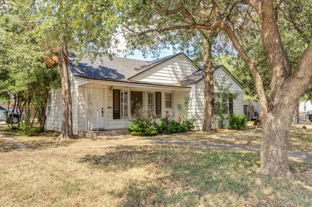 a front view of a house with a yard and potted plants