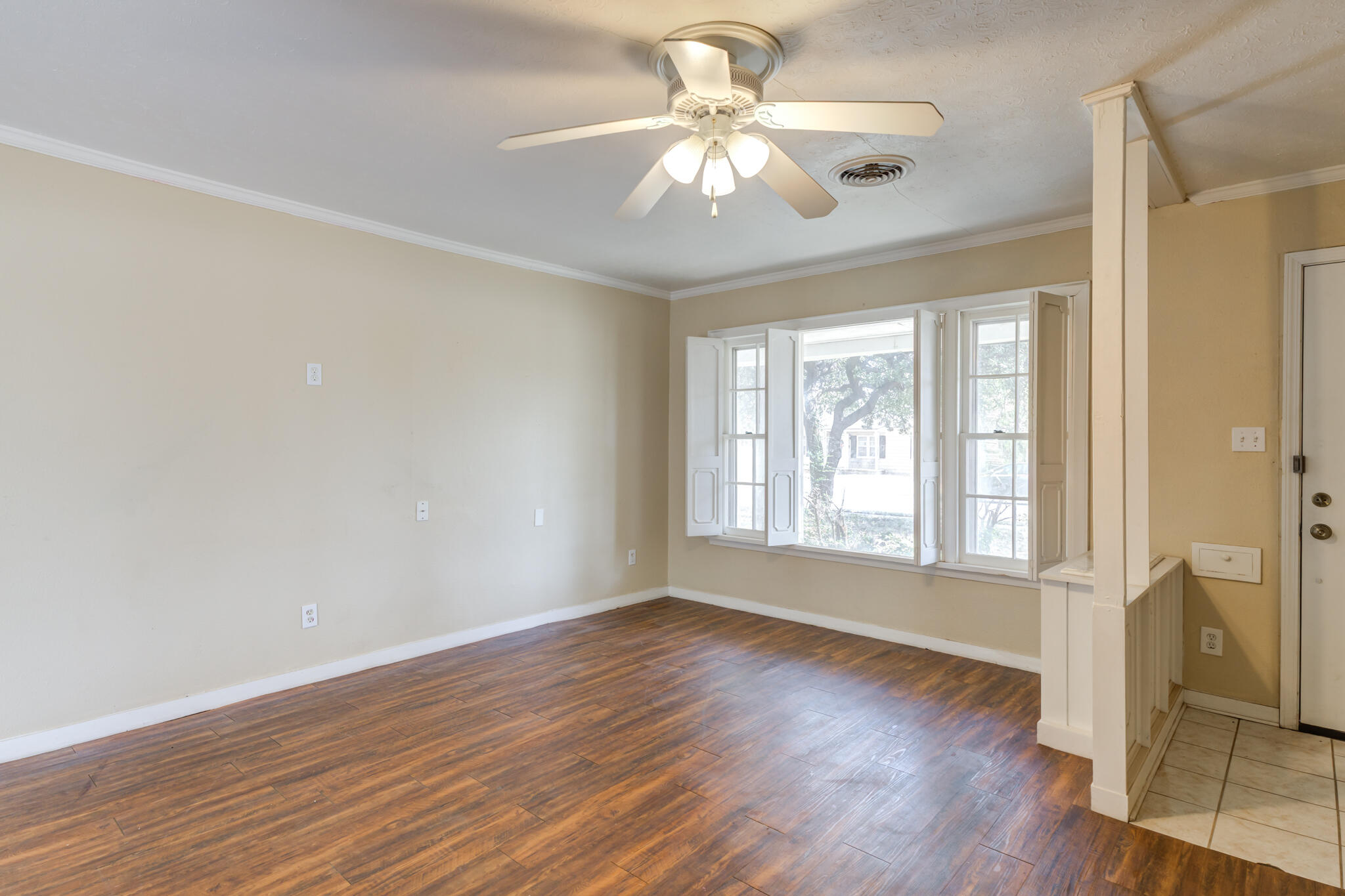 2420 39th Street Lubbock, TX 79412 - Photo 7 of 39 a view of an empty room with wooden floor and a window