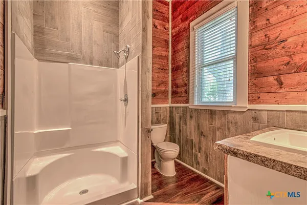 a bathroom with a granite countertop sink toilet and shower