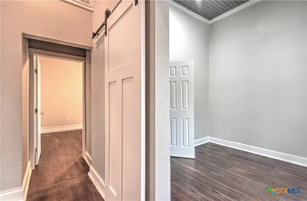 a view of a hallway with wooden floor