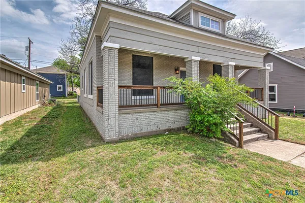 a view of a house with backyard and sitting area