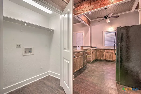 a kitchen with refrigerator cabinets and wooden floor