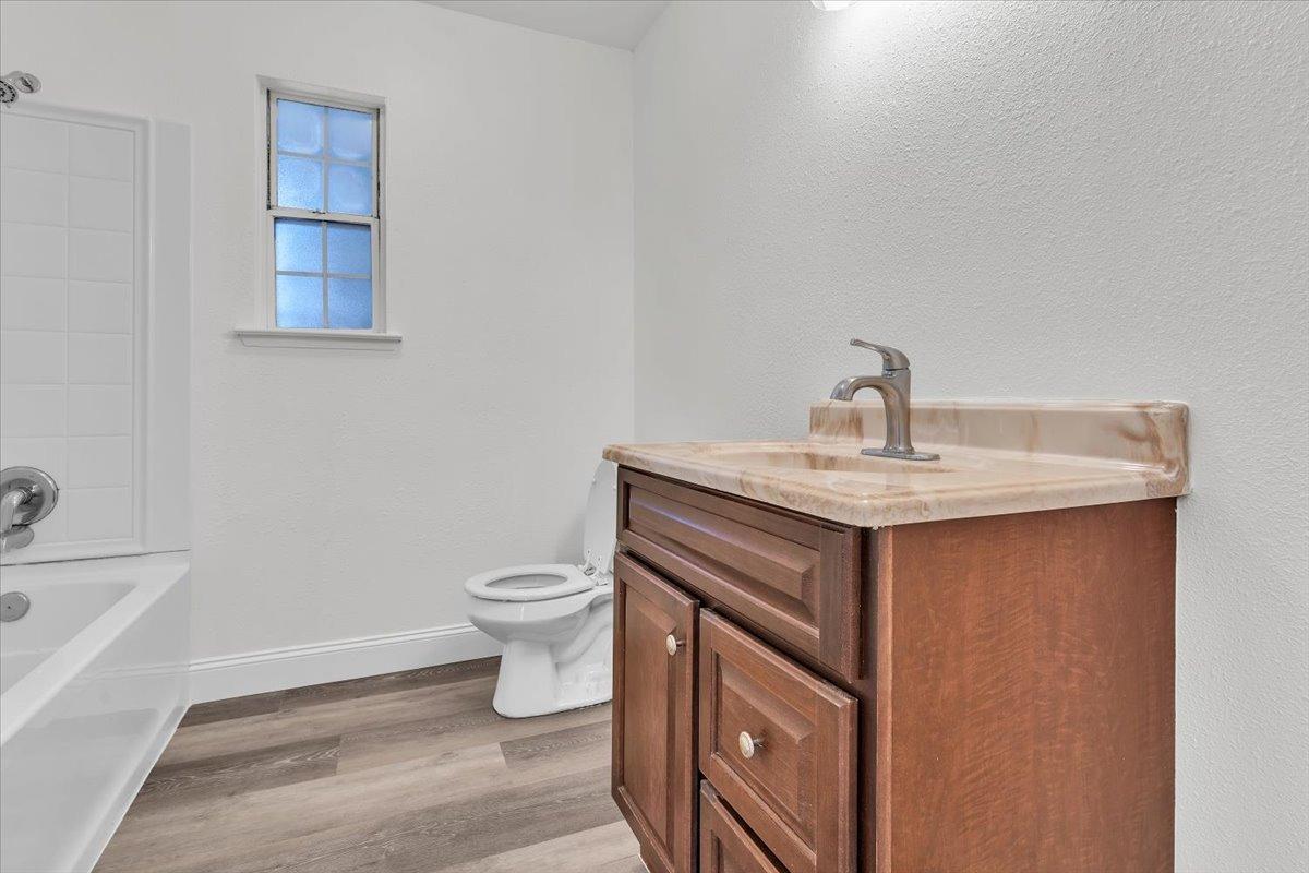 191 Orit Avenue Parlier, CA 93648 - Photo 3 of 25 a bathroom with a sink a toilet and mirror