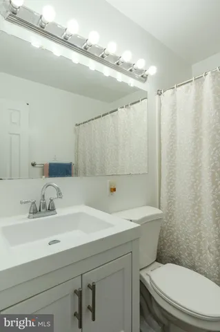 a bathroom with a sink a mirror a toilet and shower