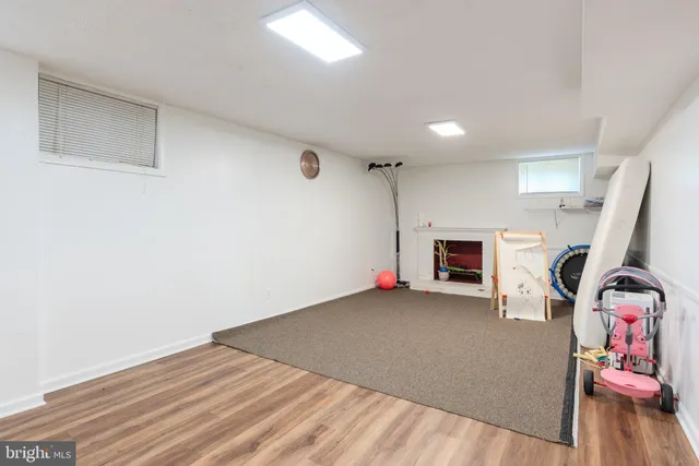 a view of empty room with fireplace and wooden floor