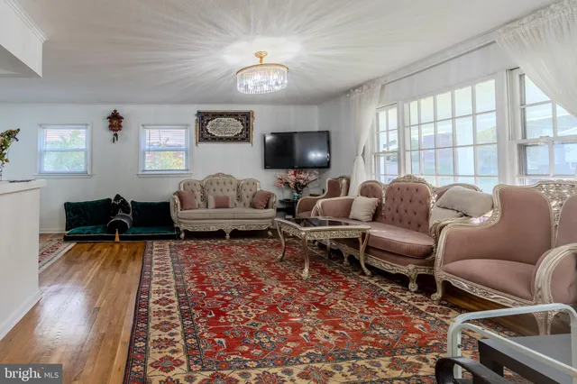 a living room with furniture flat screen tv and a large window