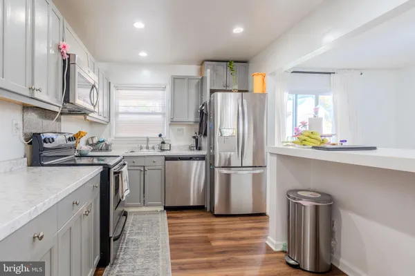 a kitchen with a refrigerator cabinets and wooden floor