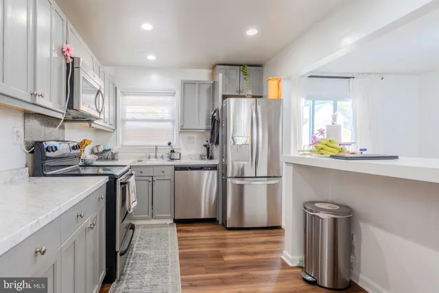 a kitchen with a refrigerator cabinets and wooden floor