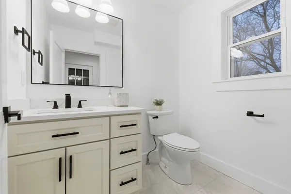 a bathroom with a sink a toilet and a mirror