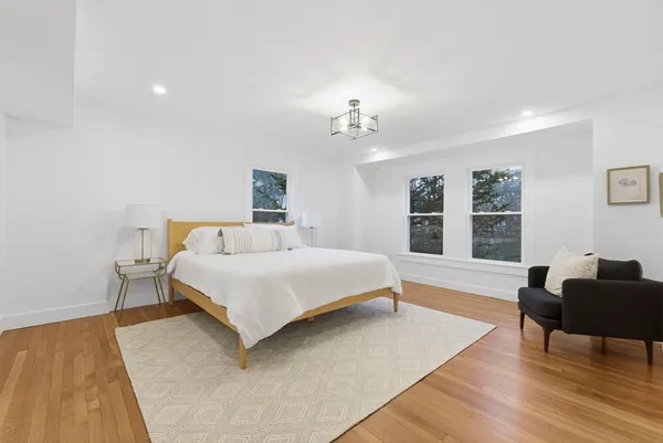 a spacious bedroom with a bed and wooden floor