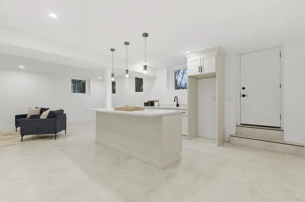 a view of kitchen with refrigerator and white cabinets