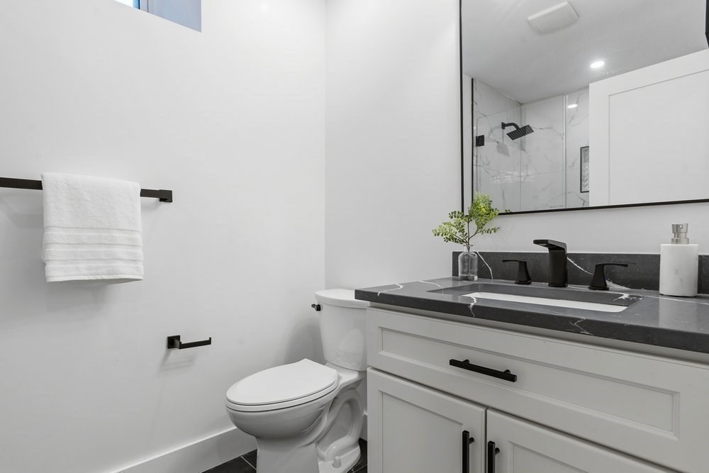 1806 Beacon Street Newton, MA 02468 - Photo 34 of 38 a bathroom with a granite countertop toilet sink and mirror