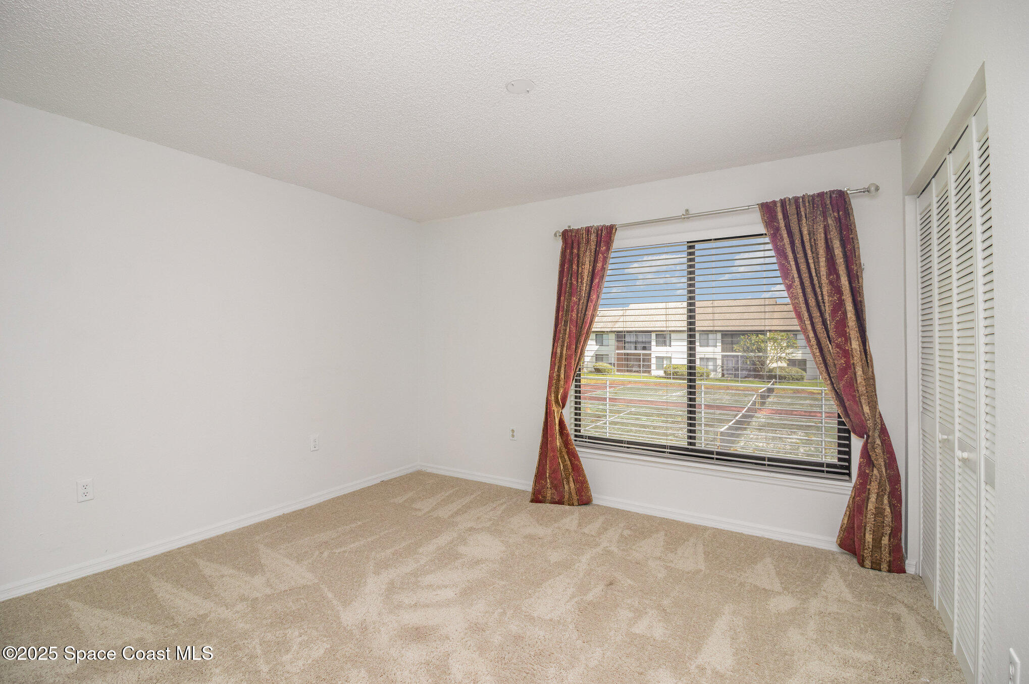 1515 Huntington Lane, Unit 626 Rockledge, FL 32955 - Photo 8 of 14 an empty room with a fireplace and large window
