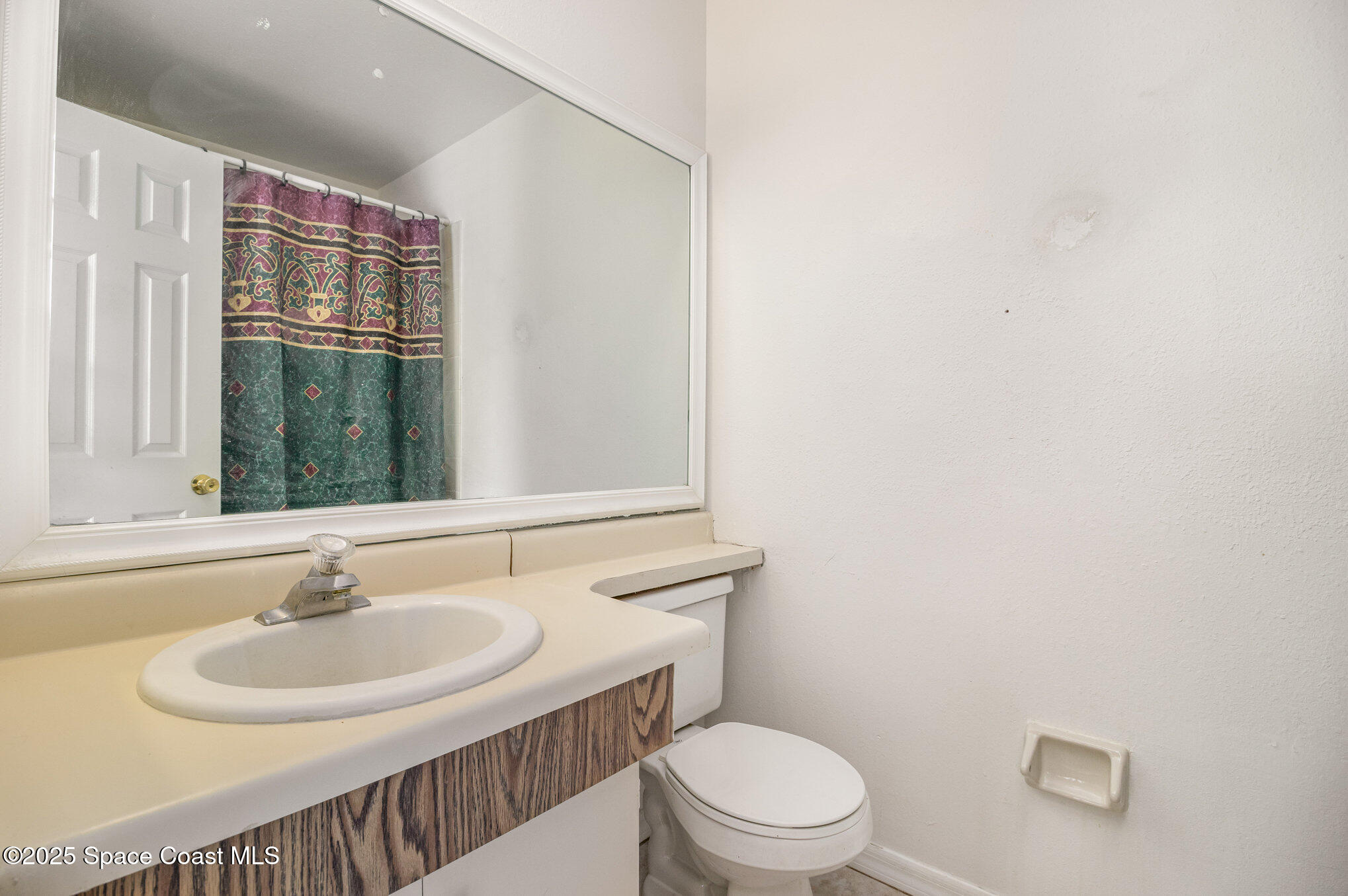 1515 Huntington Lane, Unit 626 Rockledge, FL 32955 - Photo 10 of 14 a bathroom with a sink a toilet and a mirror