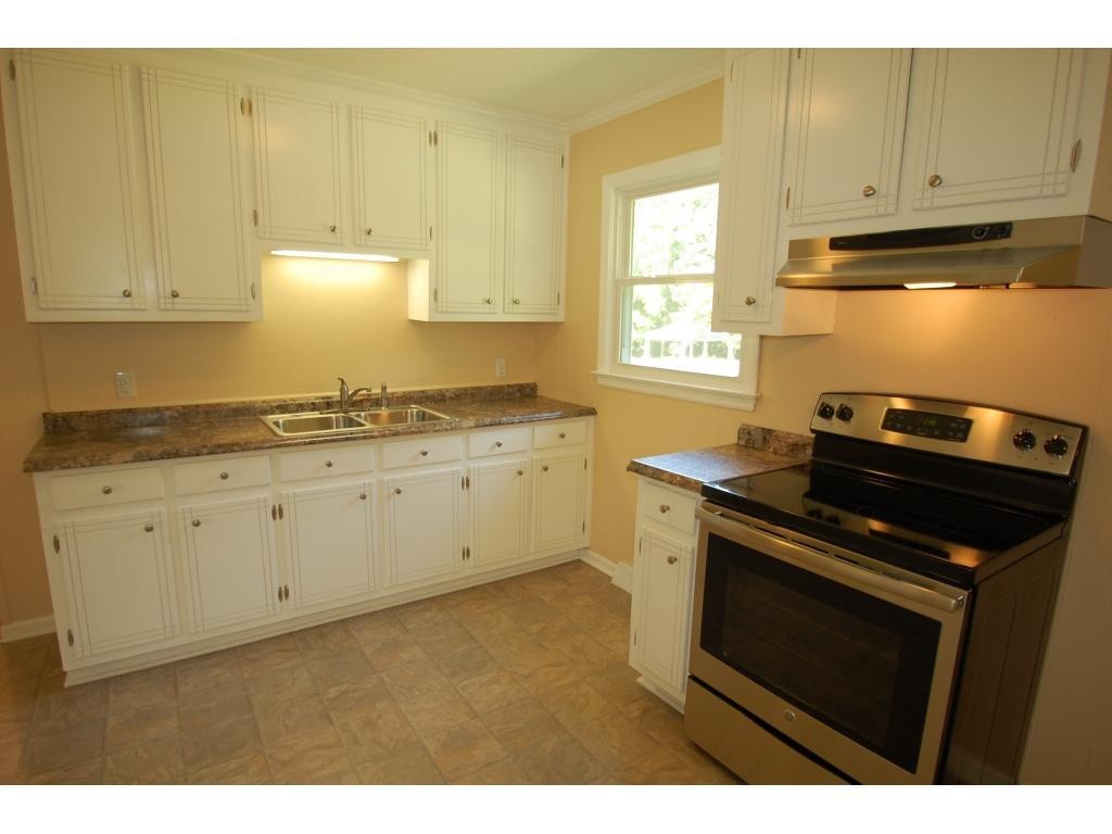 401 Lancaster Road Mebane, NC 27302 - Photo 6 of 15 a kitchen with granite countertop a stove a sink dishwasher and cabinets