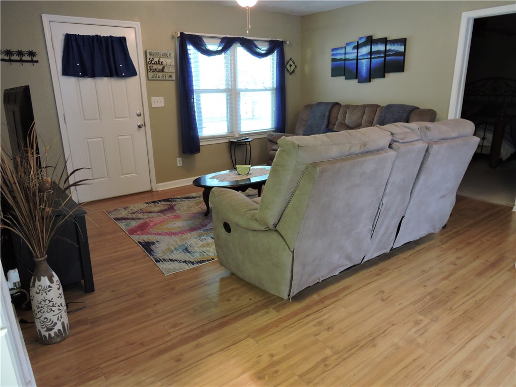 1901 Hattons Ford Road Townville, SC 29689 - Photo 11 of 33 Natural light illuminates the open-concept living space, highlighting the warm wood flooring.