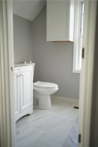 a white toilet sitting next to a bathroom sink