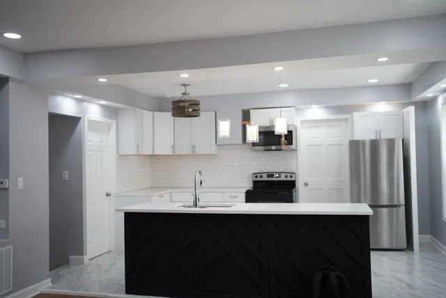 a kitchen with stainless steel appliances a sink stove and refrigerator