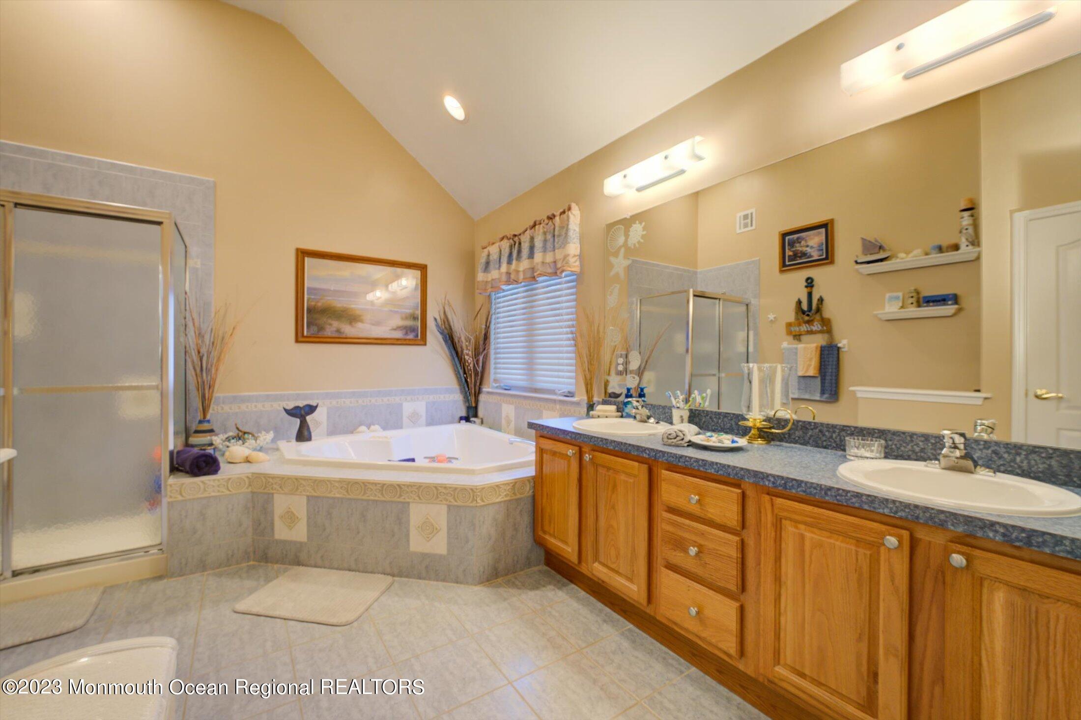 22 Rodeo Drive Jackson, NJ 08527 - Photo 19 of 42 a bathroom with a double vanity sink large mirror and a bathtub