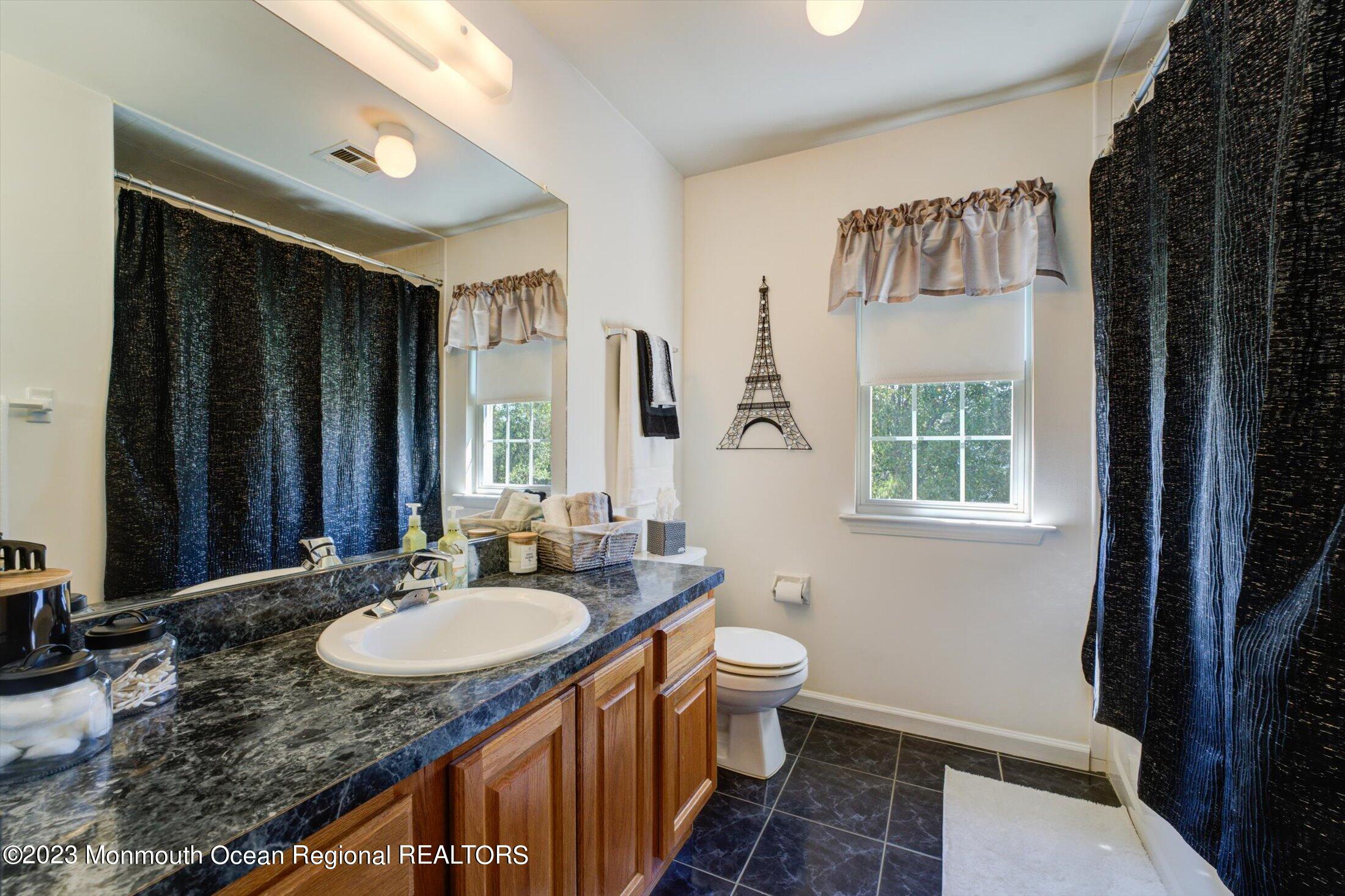 22 Rodeo Drive Jackson, NJ 08527 - Photo 23 of 42 a bathroom with a granite countertop sink and a mirror