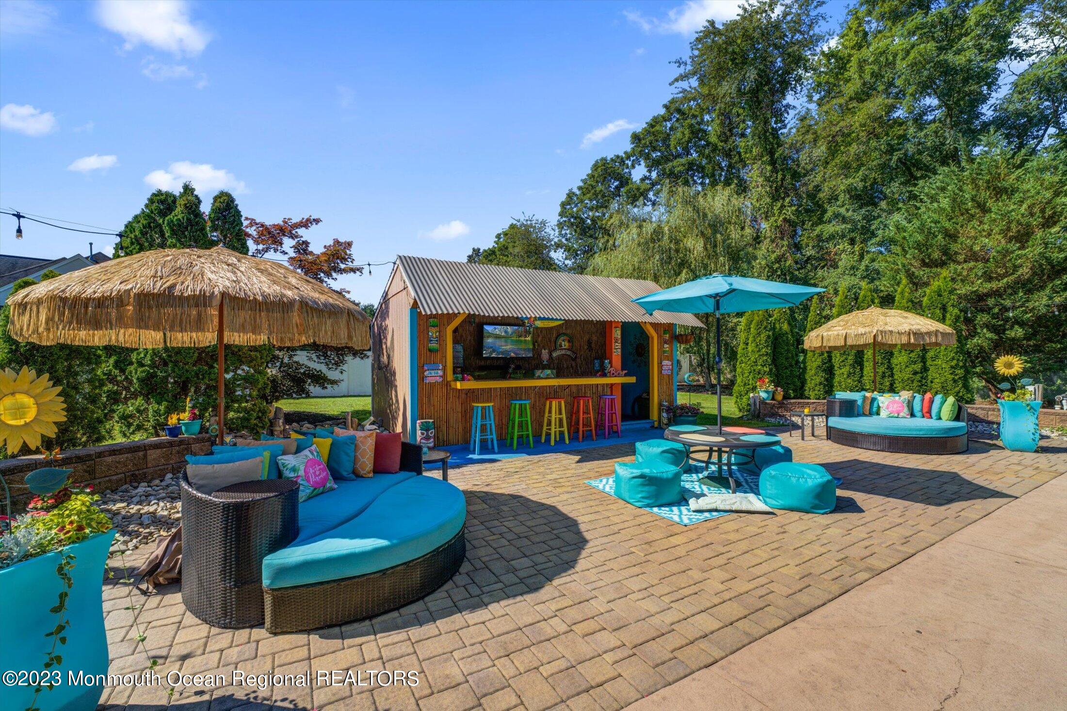 22 Rodeo Drive Jackson, NJ 08527 - Photo 32 of 42 a view of a table and chairs under an umbrella in patio with a fire pit