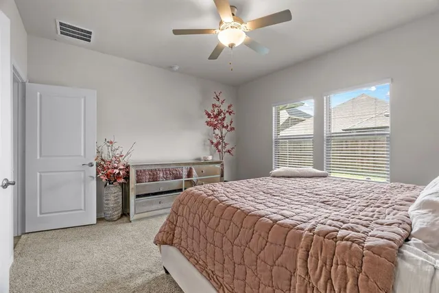 a bedroom with a bed and a ceiling fan
