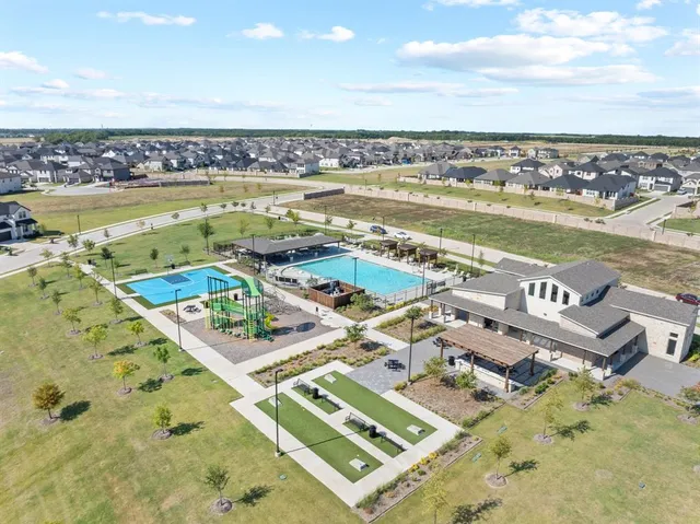 an aerial view of residential houses with outdoor space and ocean view