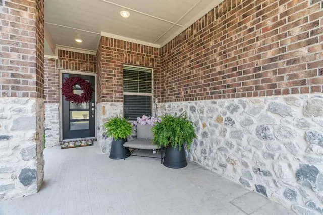 a front view of a house with potted plants