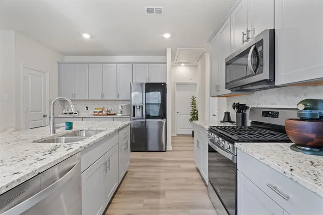 a kitchen with stainless steel appliances granite countertop a sink stove and refrigerator
