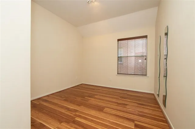 a view of a room with wooden floor and a window
