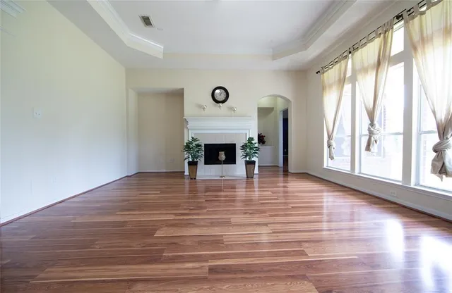 a view of a livingroom with wooden floor and a fireplace