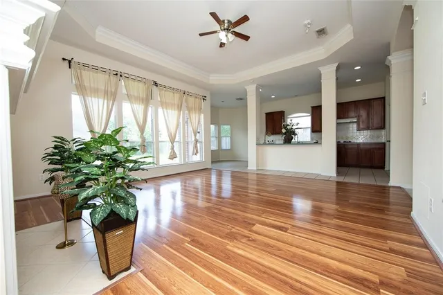 a hallway with wooden floor and a potted plant