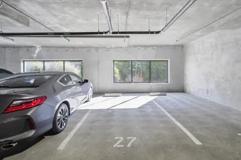 a view of parking garage with cars parked