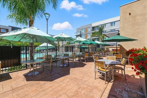 a view of a patio with a table and chairs under an umbrella
