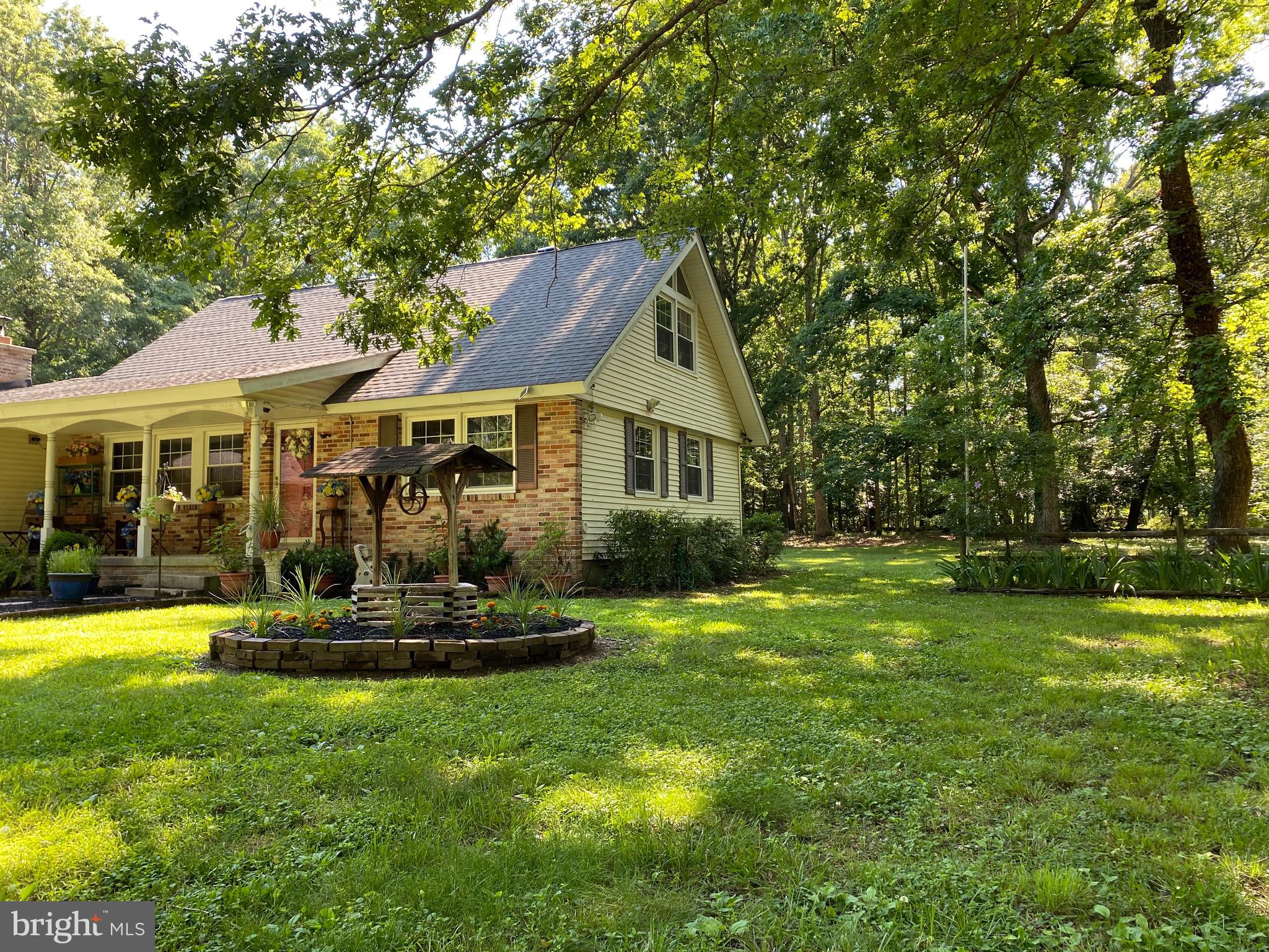 Covered front porch overlooks fruit tree orchard.
