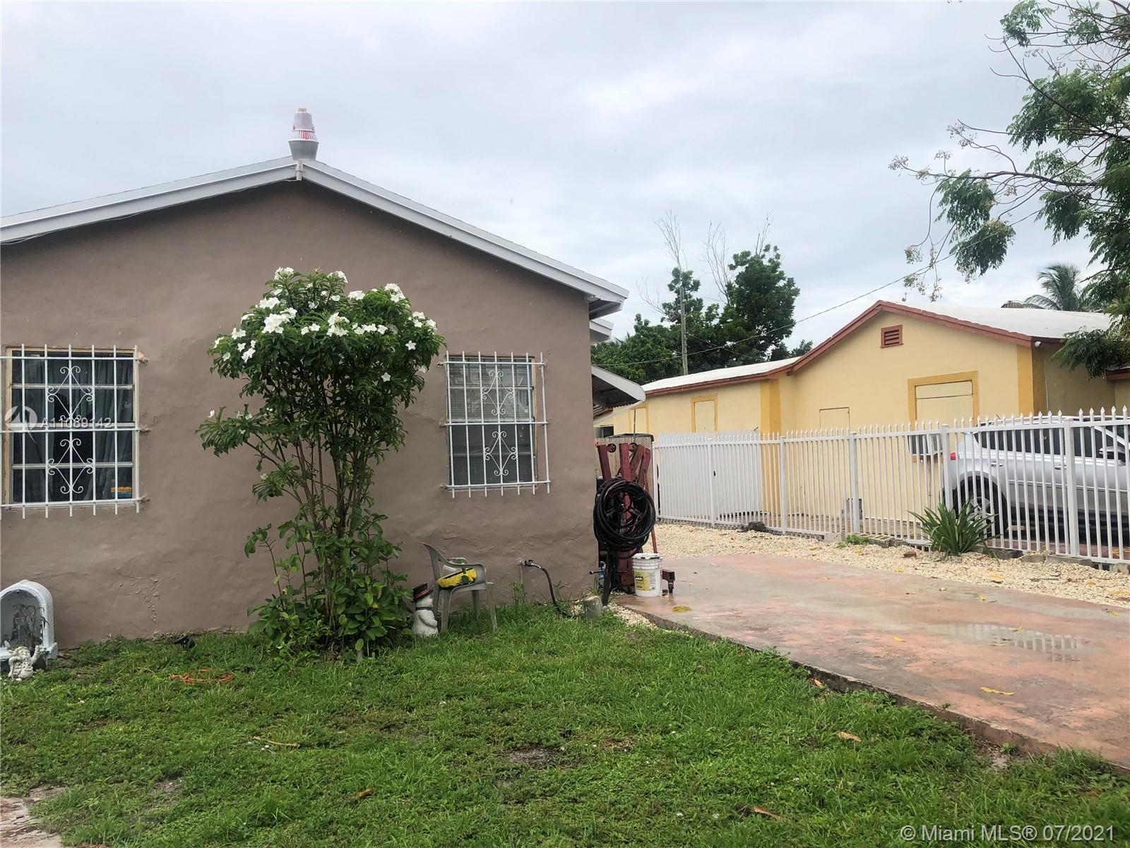 2925 Northwest 96th Street Miami, FL 33147 - Photo 2 of 11 a backyard of a house with potted plants and wooden fence