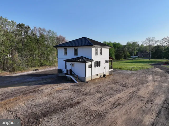 a view of a house with a yard and large tree
