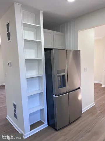 a metallic refrigerator freezer sitting in a kitchen